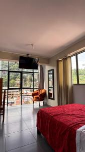 a bedroom with a red bed and a flat screen tv at Hotel Luxor Selva in La Merced +10 photos