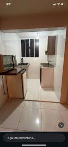 a small kitchen with black and white cabinets and appliances at Pouso do Caiçara suíte in Paraty
