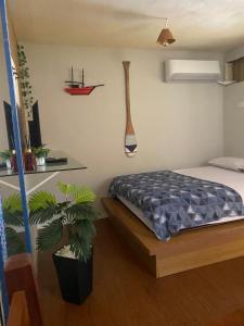 a bedroom with a bed and a potted plant at Pouso do Caiçara suíte in Paraty