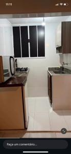 a kitchen with black and white cabinets and a sink at Pouso do Caiçara suíte in Paraty