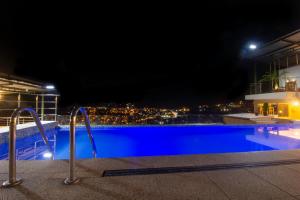 a view of a swimming pool at night at Hotel Luxor Selva in La Merced