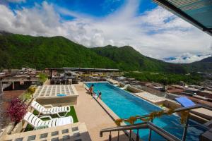 a pool on top of a building with a mountain at Hotel Luxor Selva in La Merced