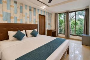 a bedroom with a large bed and windows at Hotel Sawaastic in Calangute North GOA in Calangute