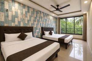 a bedroom with two beds and a window at Hotel Sawaastic in Calangute North GOA in Calangute +9 photos
