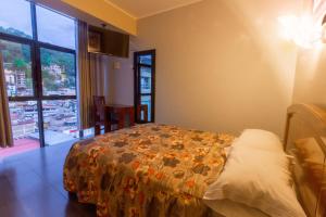a bedroom with a bed and a large window at Hotel Luxor Selva in La Merced