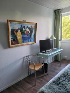 a room with a desk with a computer and a painting at Bomotel in Montluçon
