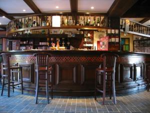 a bar with wooden bar stools in a restaurant at Bomotel in Montluçon