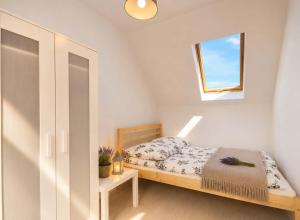 a small bedroom with a bed and a window at Domki Osada Kalinowa Nowęcin Łeba Sauna in Łeba