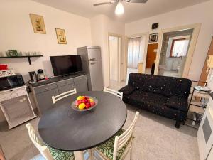 a living room with a table with a bowl of fruit on it at Ro's House in Assemini