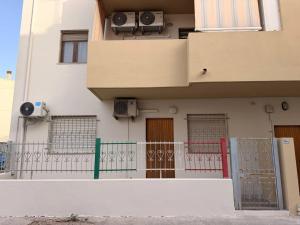 a building with a fence and a building with speakers at Ro's House in Assemini
