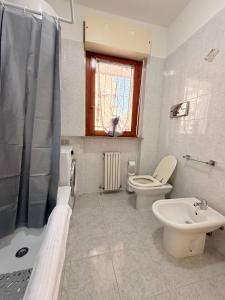 a bathroom with a toilet and a sink and a shower at Ro's House in Assemini +10 photos