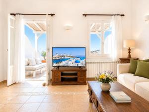 a living room with a television and a couch at Yakinthos Suites in Mykonos
