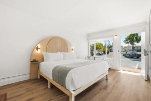 a bedroom with a large bed with a wooden headboard at Sunset Motel in Santa Barbara