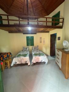 a room with two beds and a wooden ceiling at Chalé Raio De Sol in Vale do Capao