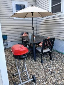 a grill and a picnic table with an umbrella at 5 blocks from the hospital! in Bismarck