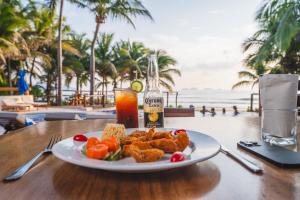 a plate of food on a table next to the beach at Escondite condominios in Zihuatanejo