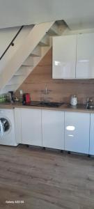 a kitchen with white cabinets and a staircase at Cap Esterel vue Mer in Agay - Saint Raphael