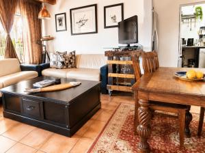 a living room with a table and a couch at Gadute Haven - Luxury Apartment in Pretoria