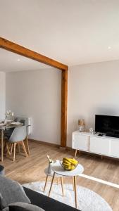 a living room with a couch and a table at Joli triplex proche Colmar in Sainte-Croix-en-Plaine