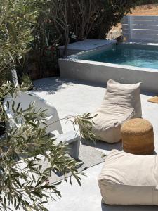 a patio with a pillow and a chair next to a pool at LETIHOME Paros in Kampos Paros
