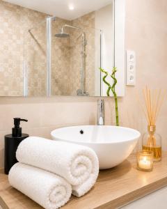 a bathroom with a white sink and towels on a counter at Apartamento Premium Ávila PLAZA MAYOR con PARKING in Ávila