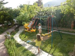 two children playing on a swing set in a yard at La Maison Nature , Mountains View Suite in Ourika