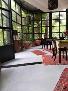 a conservatory with a table and chairs and windows at La Maison Nature , Mountains View Suite in Ourika
