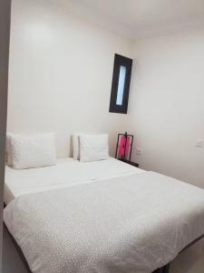 a bedroom with a large white bed with a black frame at La Maison Nature , Mountains View Suite in Ourika