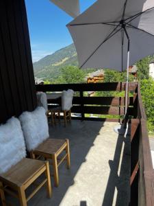 a patio with a table and chairs and an umbrella at Chaletttt large and magnificent view in Valmorel