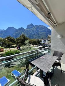 a balcony with a table and chairs and mountains at Appartement Vista Lago in Riva del Garda