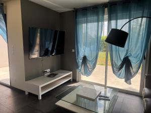 a living room with a tv and a window at Normandy lodges in Le Dézert