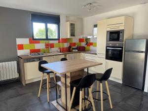 a kitchen with a wooden table and chairs at Normandy lodges in Le Dézert