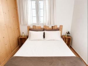 a bedroom with a bed with white sheets and a window at Formentera suite 14 in Es Pujols