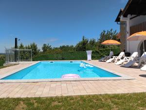 a small swimming pool with chairs and an umbrella at Villa Bavaria in Ritopek