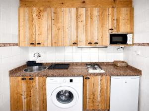 a kitchen with a washing machine and a sink at Formentera suite 14 in Es Pujols +24 photos