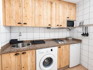 a kitchen with a sink and a washing machine at Formentera suite 14 in Es Pujols