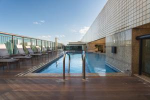 a swimming pool in the middle of a building at Lindo Flat Part Grand Mercure Varanda aconchegante in Brasília