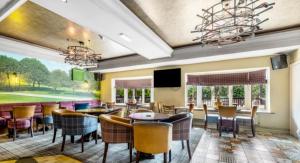 a dining room with tables and chairs and a television at The Fairways Pub in Templebrough