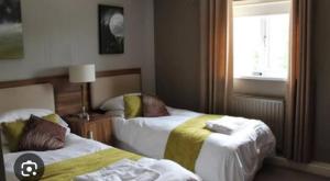 a hotel room with two beds and a window at The Fairways Pub in Templebrough