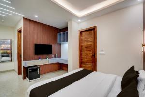 a bedroom with a bed and a television in it at Hotel O Maruti Hotel in Indirapuram +23 photos