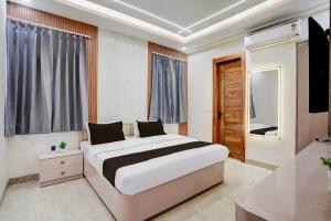 a bedroom with a large bed and a television at Hotel O Maruti Hotel in Indirapuram