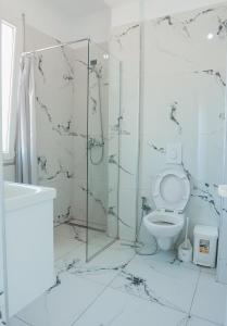 a white bathroom with a shower and a toilet at EBIS HOTEL in Shëngjin +42 photos