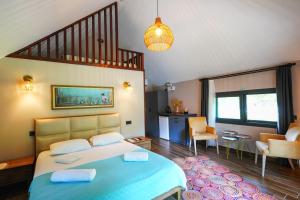 a bedroom with a blue bed and a living room at Dalyan Riverside Private Gaia Koru Bungalows with Swimming Pool Adults Only in Ortaca