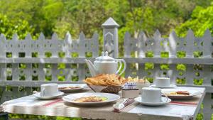 a table with plates of food and a tea kettle at Ella Scenic Heights in Ella