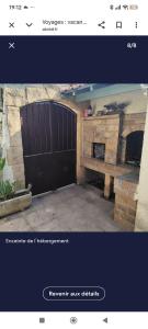 a garage with a black door and a brick fireplace at Villa Oasis Bollène in Bollène