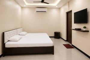 a bedroom with a bed and a flat screen tv at Hotel O Boby Royal Palace in Pratāpgarh