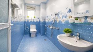 a blue bathroom with a toilet and a sink at Hotel O Boby Royal Palace in Pratāpgarh +1 photo
