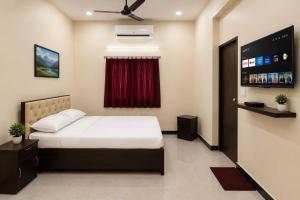 a bedroom with a bed and a red curtain at Hotel O Boby Royal Palace in Pratāpgarh