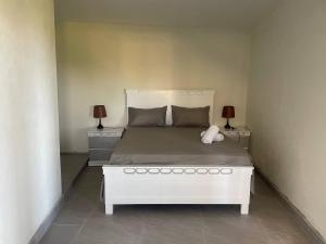 a bedroom with a white bed with two night stands at Rico Puerto magic spot east in Cabrera +5 photos