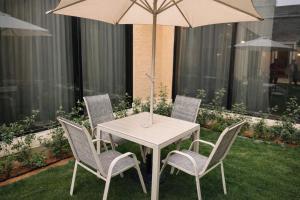 a white table and chairs with an umbrella at منتجع ليورا ــ Liora Resort in Al Ḩanī